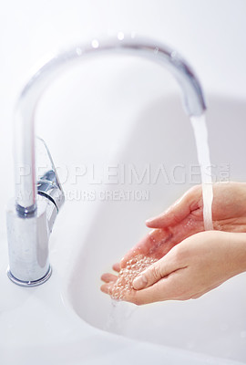 Buy stock photo Water, cleaning and washing hands in bathroom for health, hygiene or wellness in home. Fingers, liquid and palm of person at sink with bubbles to remove bacteria, virus or dirt for safety closeup