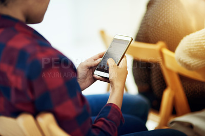 Buy stock photo Shot of a young man using a cellphone in an office
