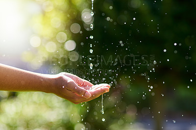 Buy stock photo Shot of hands held out to catch a stream of water outside