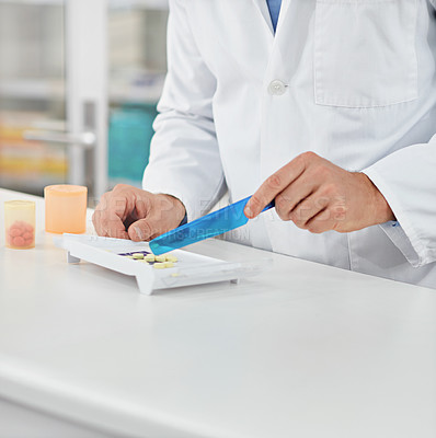Buy stock photo Cropped shot of a pharmacist counting medication. All products have been altered to be void of copyright infringements