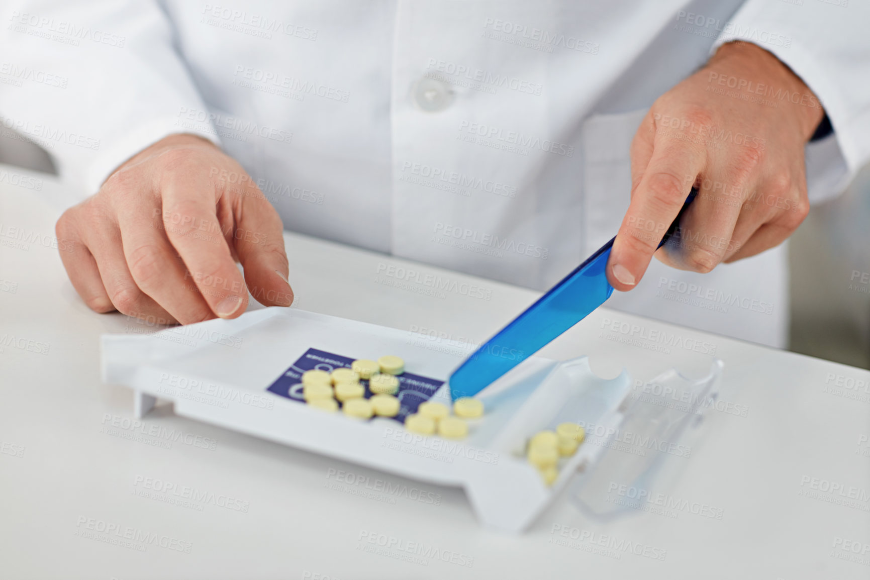 Buy stock photo Cropped shot of a pharmacist counting medication