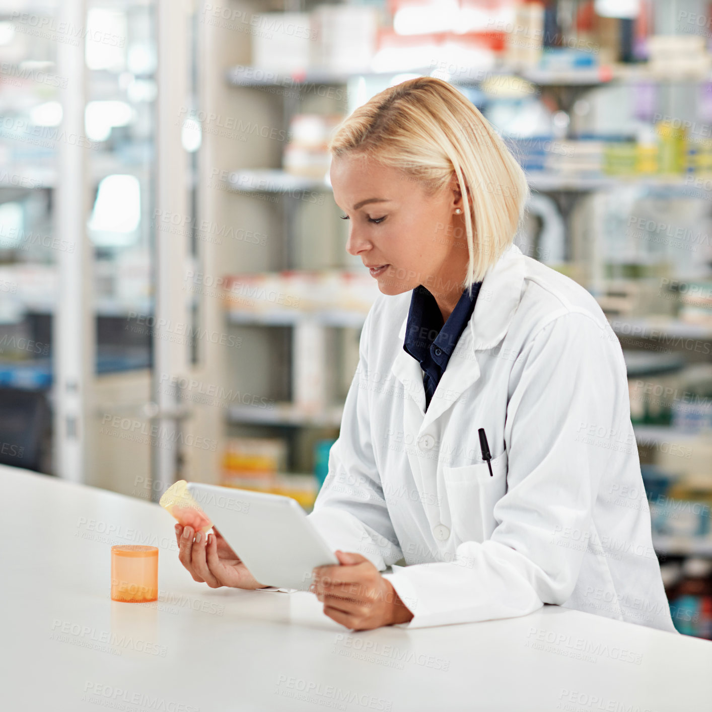 Buy stock photo Woman pharmacist in pharmacy, tablet and pill bottle for medical research and check side effects of medicine. Technology, internet with online info on pharmaceutical drugs and health professional