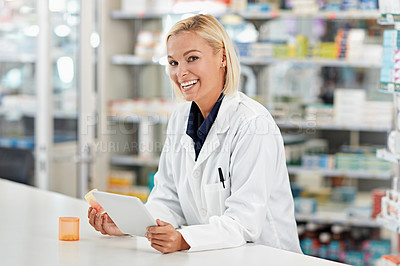 Buy stock photo Shot of a pharmacist doing some research on a digital tablet. All products have been altered to be void of copyright infringements