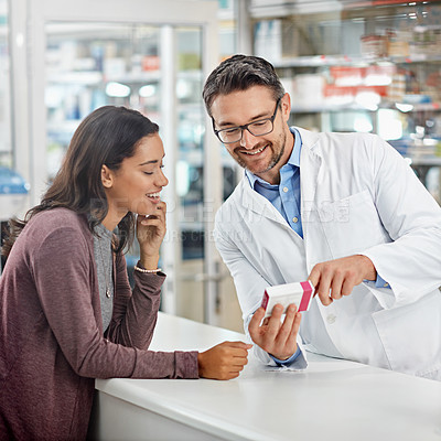 Buy stock photo Shot of a male pharmacist assisting a customer at the prescription counter. All products have been altered to be void of copyright infringements