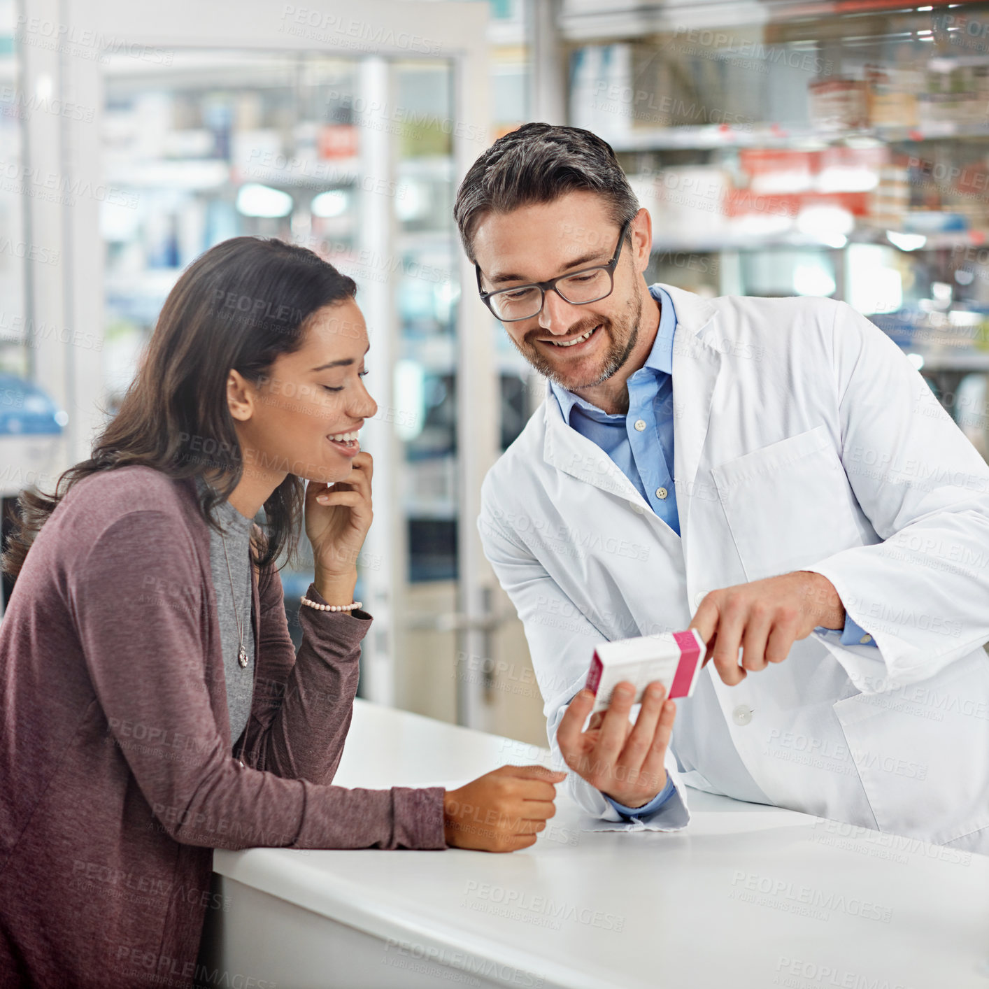 Buy stock photo Shot of a male pharmacist assisting a customer at the prescription counter. All products have been altered to be void of copyright infringements