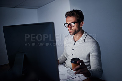 Buy stock photo Shot of a handsome young man working late on a computer