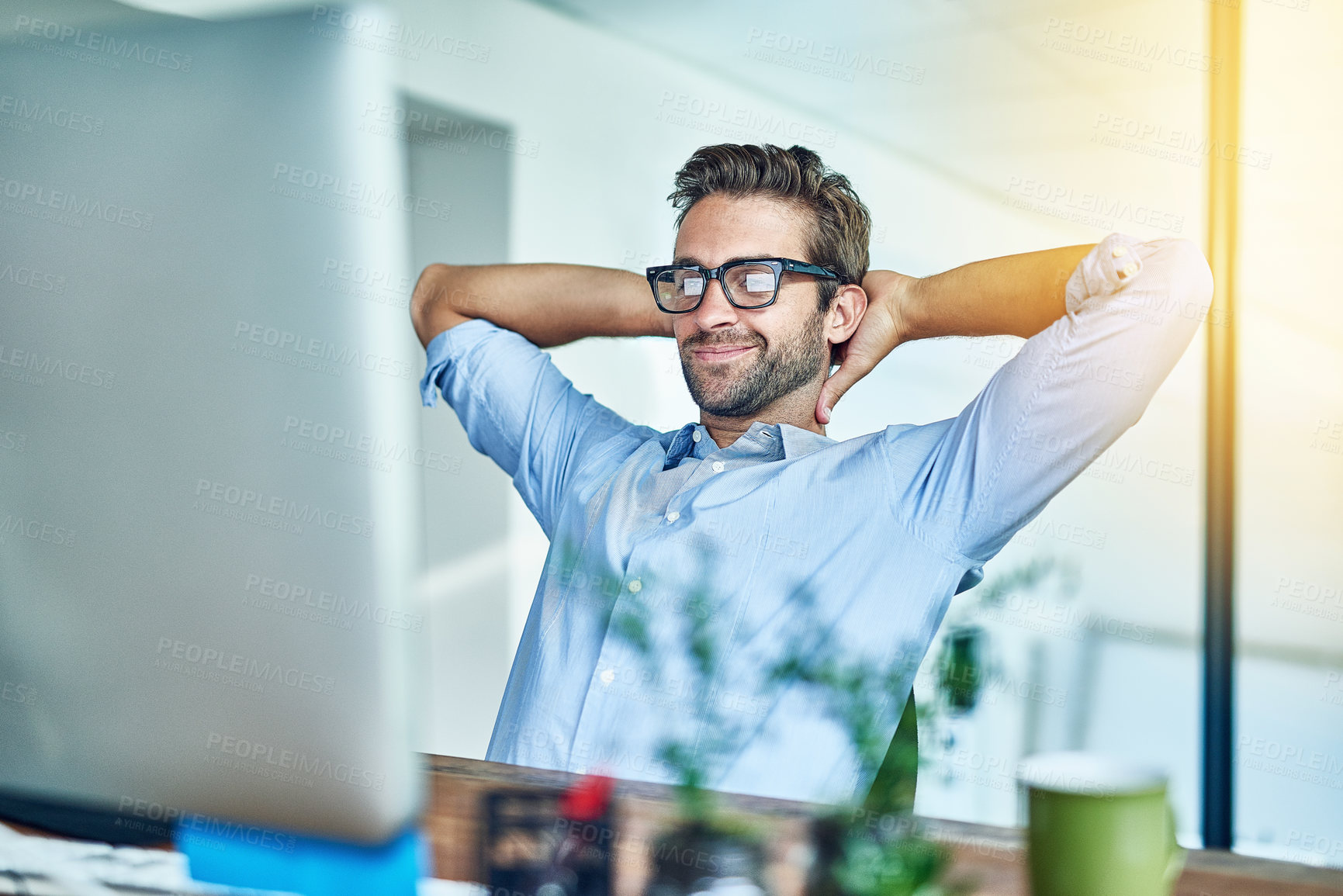 Buy stock photo Shot of a young businessman taking a break in an office