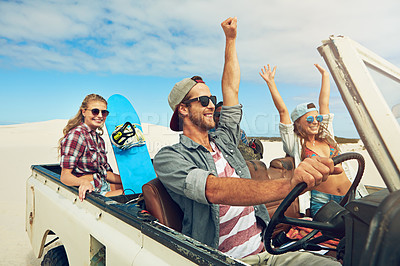Buy stock photo Shot of a group of young friends going on a sand boarding road trip in the desert