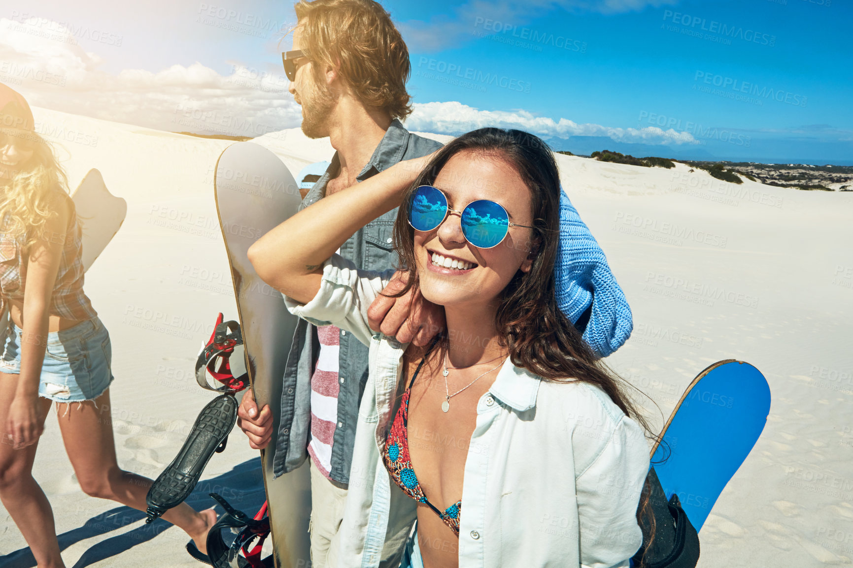 Buy stock photo Shot of a group of young friends sandboarding in the desert