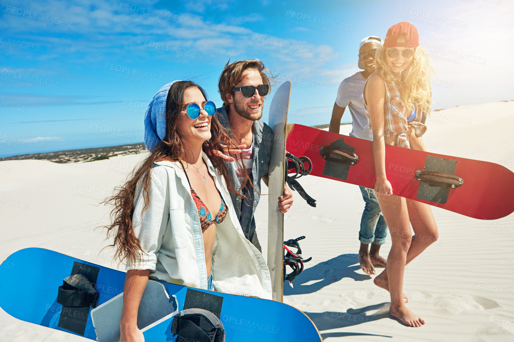 Buy stock photo Shot of a group of young friends sandboarding in the desert