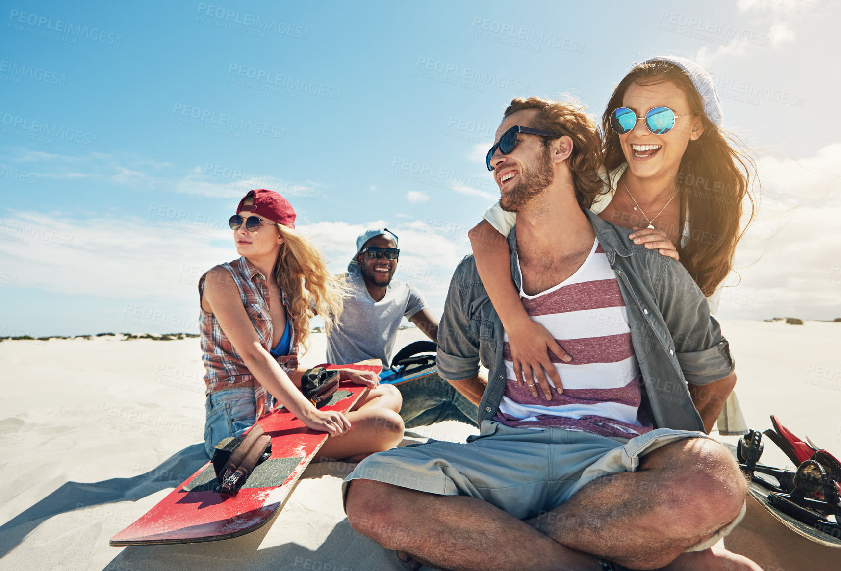 Buy stock photo Shot of a group of young friends sandboarding in the desert