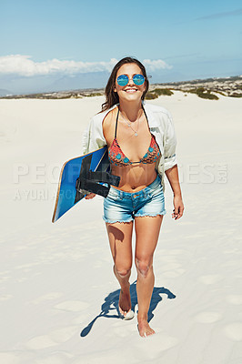 Buy stock photo Shot of a young woman sand boarding in the desert