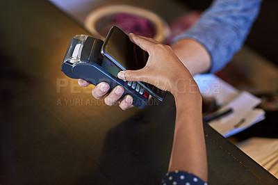 Buy stock photo Shot of a woman paying using NFC technology in a cafe