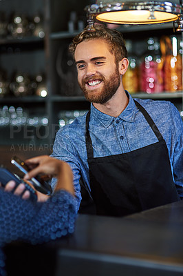Buy stock photo Shot of a waiter accepting a payment using NFC technology in a cafe
