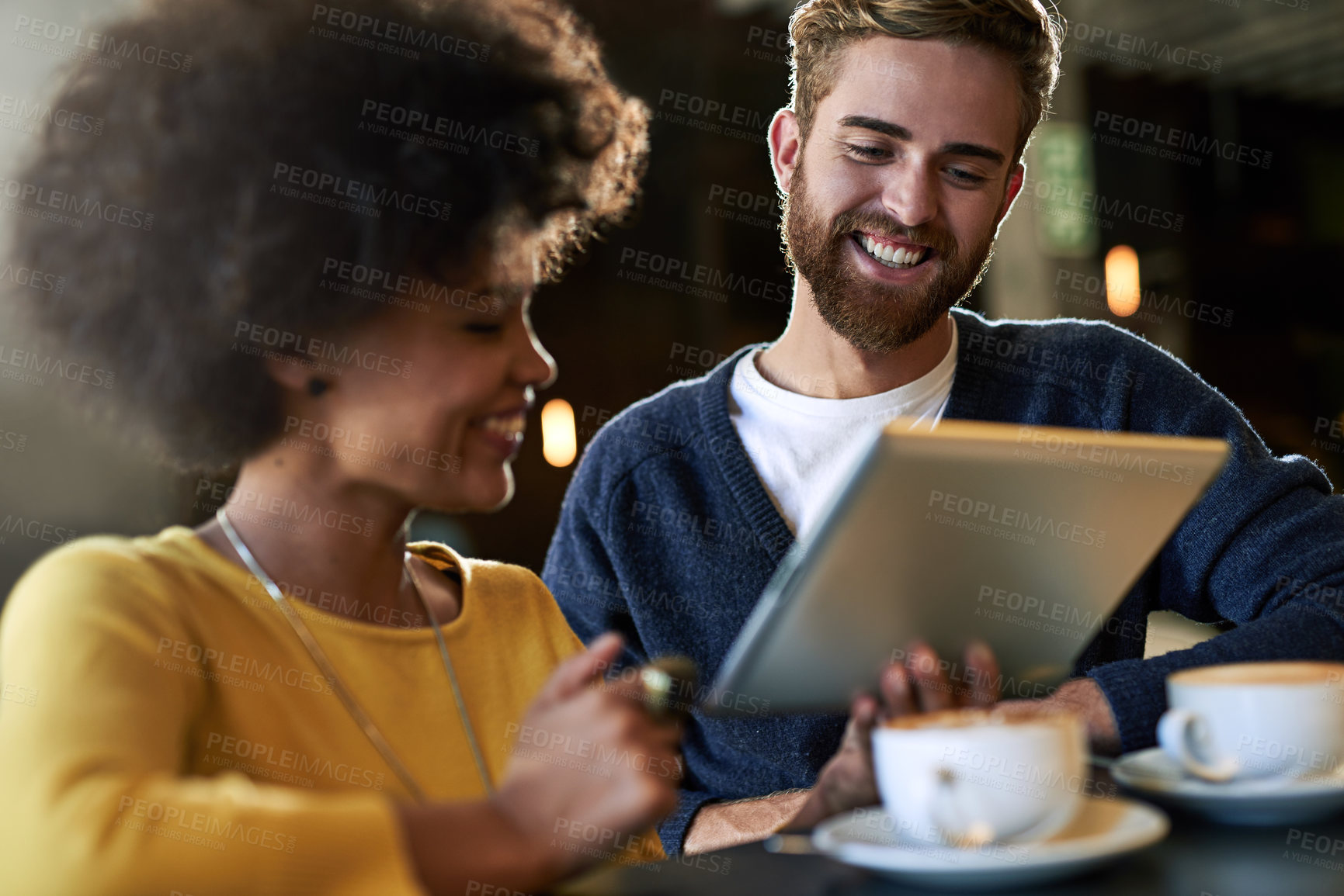 Buy stock photo Shot of two people using a digital tablet in a cafe