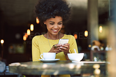 Buy stock photo Shot of a young woman texting on a cellphone in a cafe
