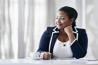 Buy stock photo Shot of a young businesswoman drinking a coffee while working at a desk in an office