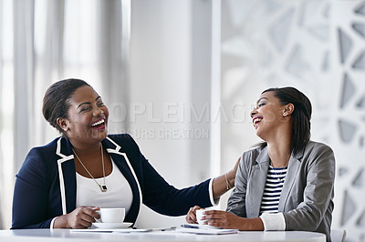 Buy stock photo Shot of two coworkers laughing together while sitting at a desk in an office