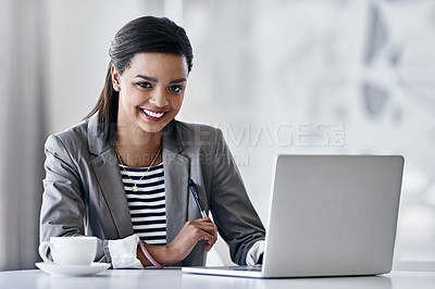 Buy stock photo Portrait of a young businesswoman using a laptop while sitting at a desk in an office