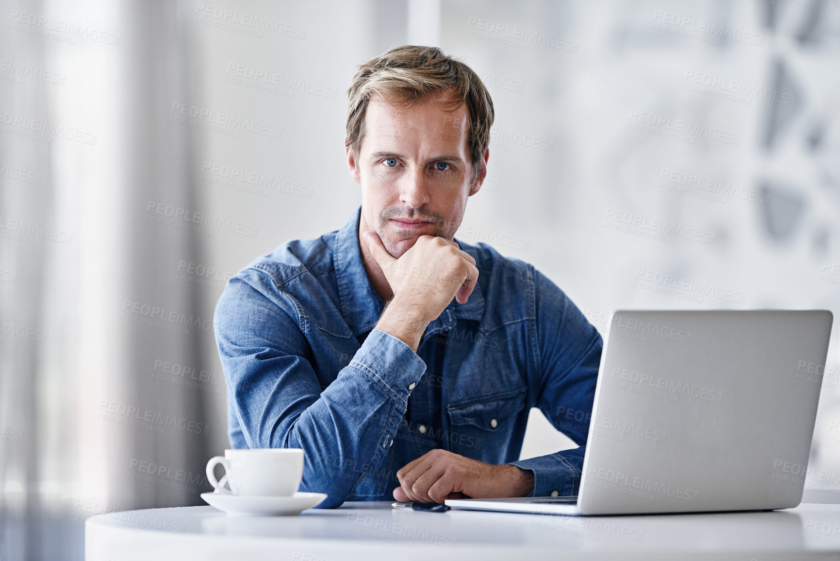 Buy stock photo Portrait of a mature businessman using a laptop while sitting at a desk in an office