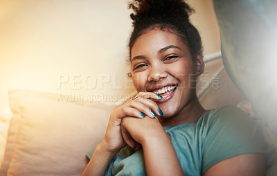 Buy stock photo Cropped portrait of a young woman sitting on her bed