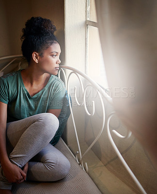 Buy stock photo High angle shot of a young woman sitting on her bed
