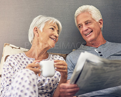 Buy stock photo Coffee, newspaper and a mature couple in bed, enjoying retirement in their home in the morning. Tea, reading or love with a happy senior man and woman in the bedroom together to relax while bonding