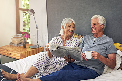 Buy stock photo Coffee, newspaper and a mature couple in the bedroom, enjoying retirement in their home in the morning. Tea, reading or love with a happy senior man and woman in bed together to relax while bonding