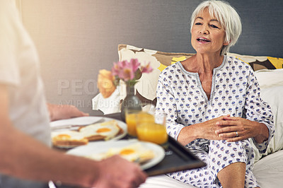 Buy stock photo Shot of a senior man bringing his wife breakfast in bed