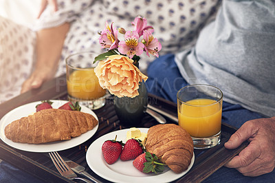 Buy stock photo Cropped shot of a senior couple having breakfast in bed