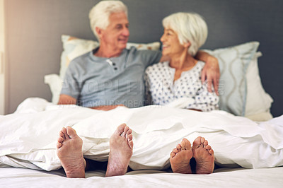 Buy stock photo Shot of a senior couple lying in bed