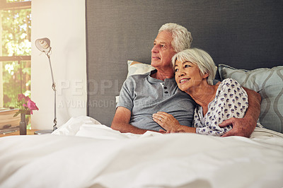 Buy stock photo Shot of a senior couple lying in bed