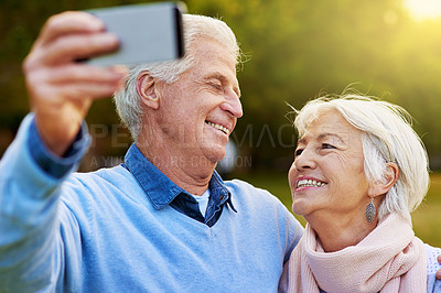 Buy stock photo Shot of a senior couple taking a photo together in a park