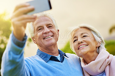 Buy stock photo Shot of a senior couple taking a photo together in a park