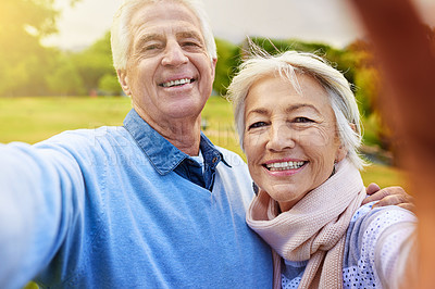 Buy stock photo Portrait of a senior couple taking a photo together in a park