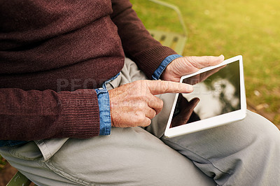 Buy stock photo Closeup shot of a man using a digital tablet in the park