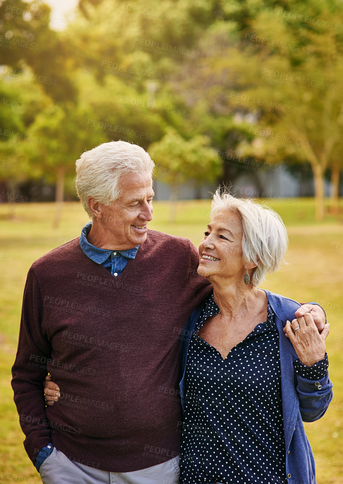 Buy stock photo Old couple, hug and holding hands while in the park, smile and happiness together with bonding in nature, love in retirement. Happy, man and woman travel, relationship with marriage and commitment