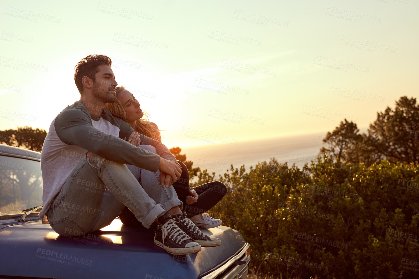 Buy stock photo Shot of an affectionate young couple on a roadtrip