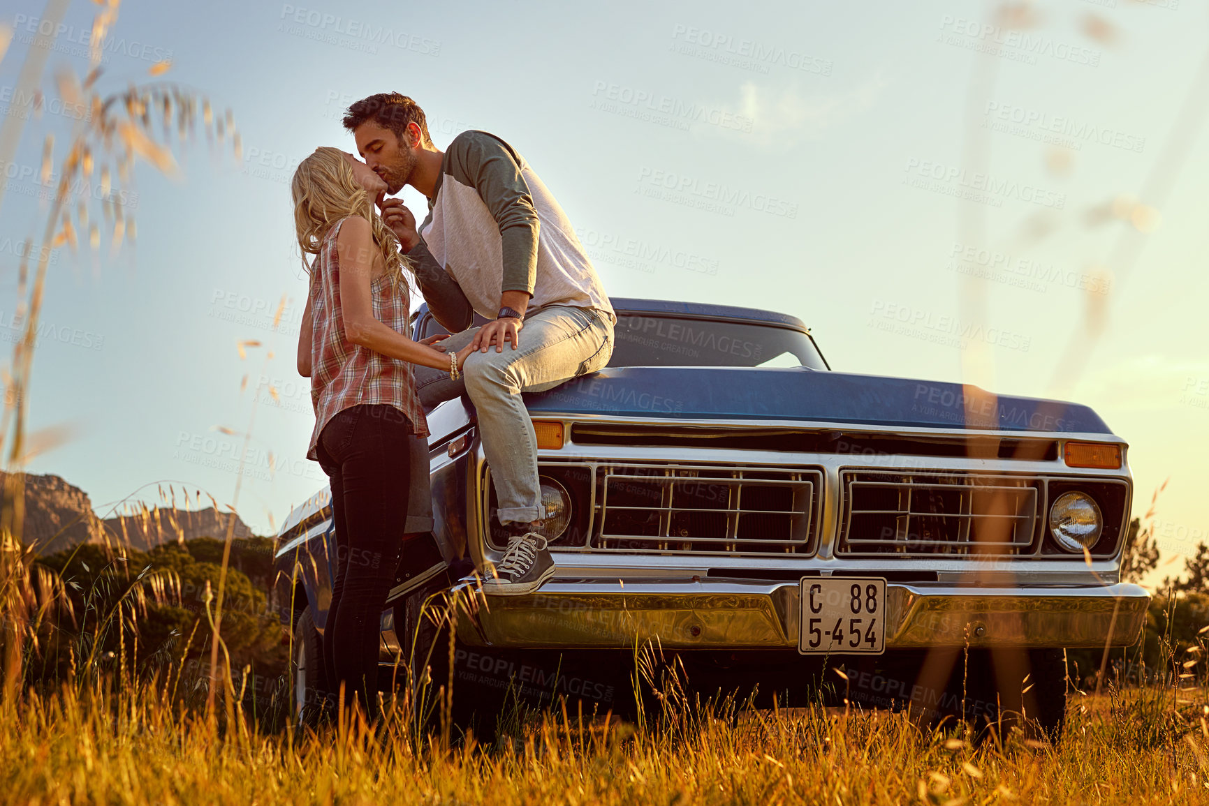 Buy stock photo Shot of an affectionate young couple on a roadtrip