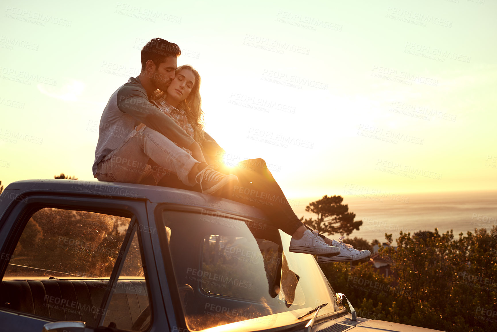 Buy stock photo Shot of an affectionate young couple on a roadtrip