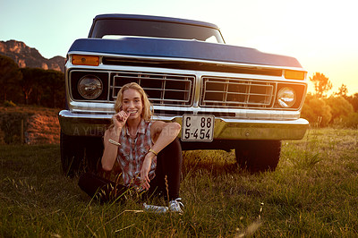 Buy stock photo Portrait of an attractive young woman sitting in front of her truck on a roadtrip