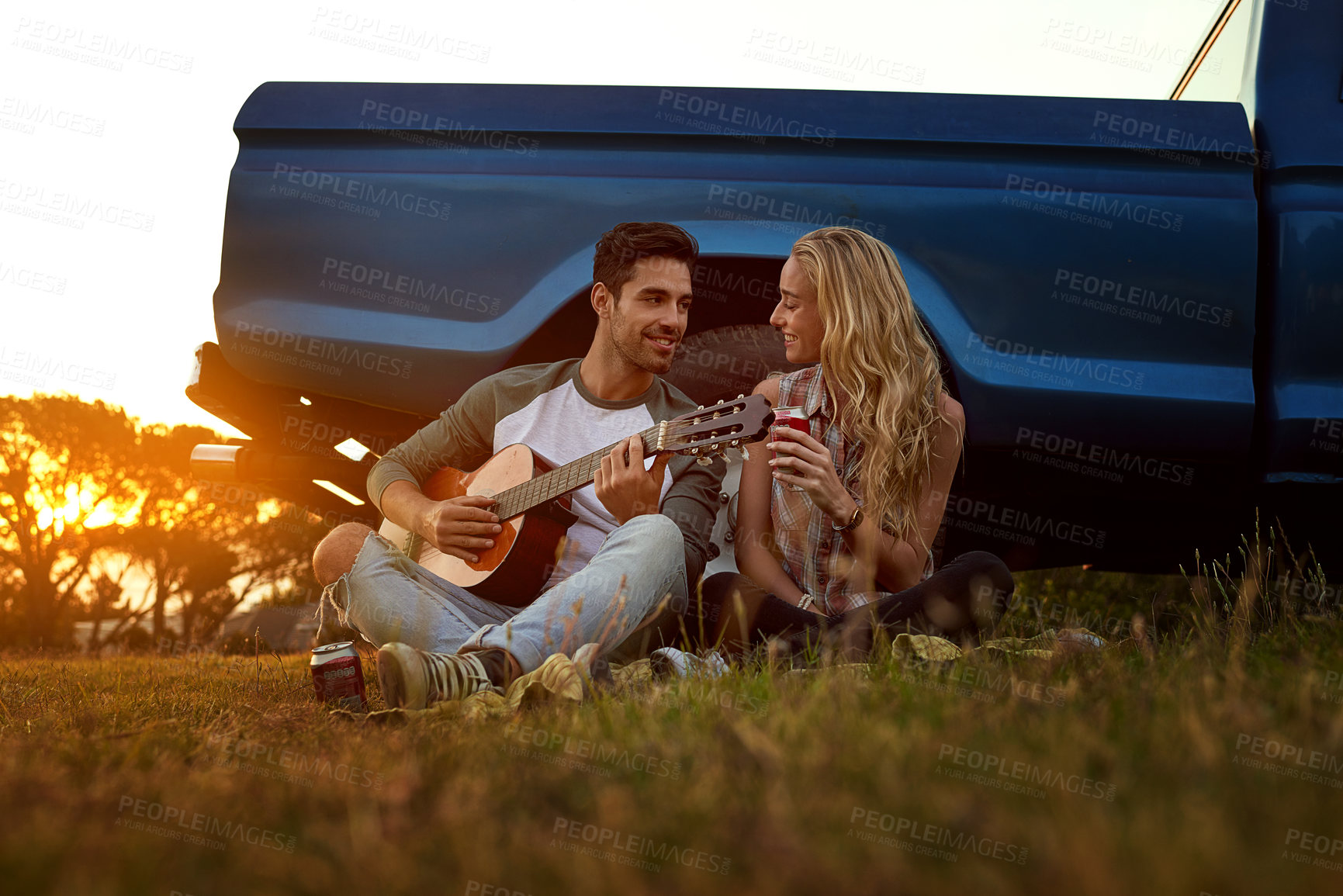 Buy stock photo Guitar, nature and couple playing music by sunset on date for romantic getaway road trip. Happy, outdoor and man serenading woman by truck with string instrument in field for vacation or holiday.