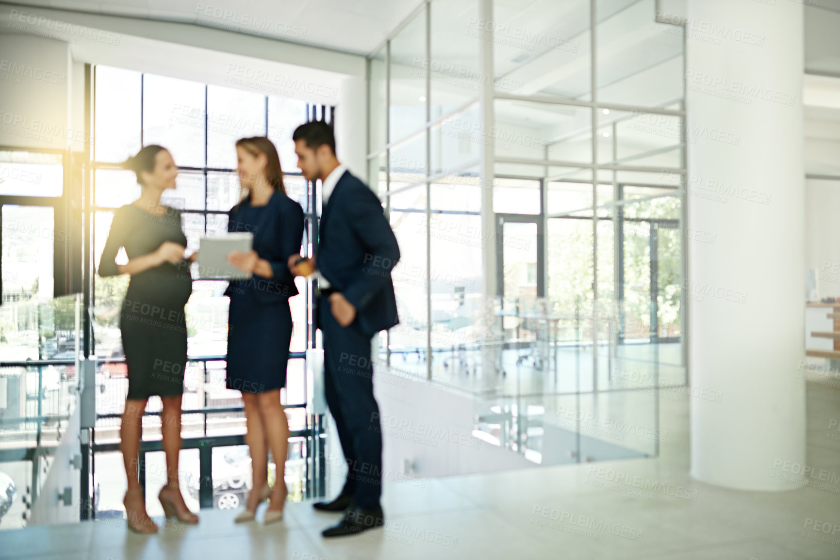 Buy stock photo Shot of a group of businesspeople talking together over a digital tablet in a modern office