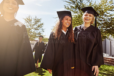 Buy stock photo Shot of a group of smiling university students outside on graduation day