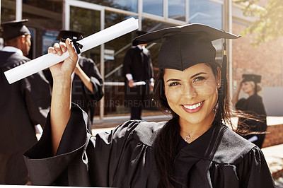 Buy stock photo Portrait of a smiling university student holding her diplomas outside on graduation day