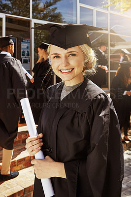 Buy stock photo Portrait of a smiling university student holding her diploma outside on graduation day