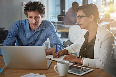 Buy stock photo Shot of businesspeople working on a laptop in an office