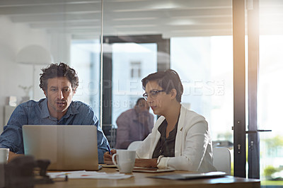 Buy stock photo Shot of businesspeople working on a laptop in an office