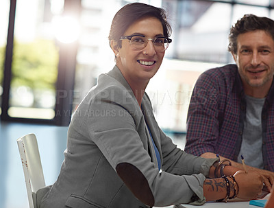Buy stock photo Cropped portrait of two colleagues sitting in the office during a meeting