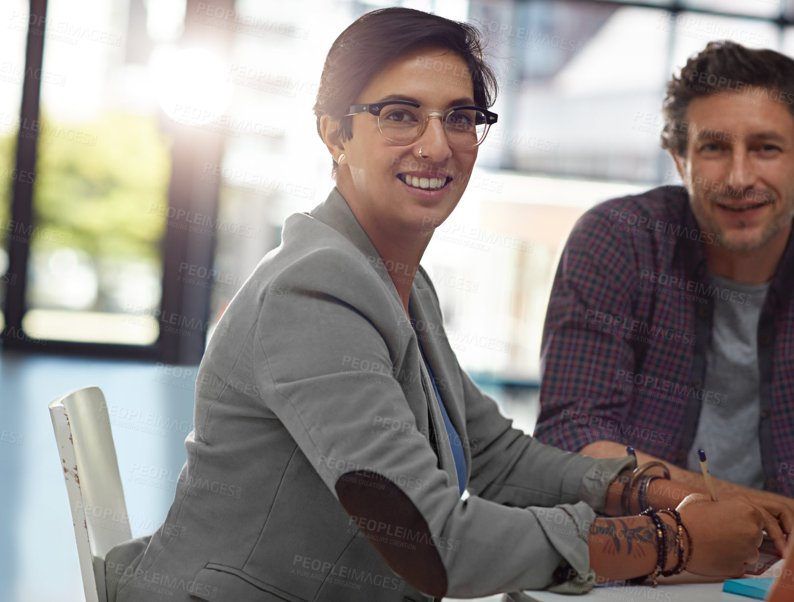 Buy stock photo Cropped portrait of two colleagues sitting in the office during a meeting